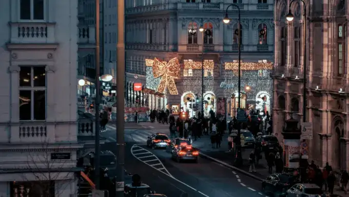 Weihnachtlich geschmückte, nachts beleuchtete Straße in Wien